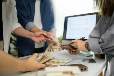 İç mimarlar grubu malzeme örnekleri seçiyor, yaratıcı ofiste birlikte çalışıyorlar..
