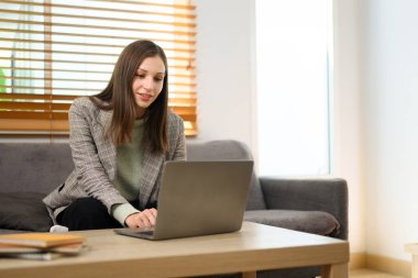 Evde dizüstü bilgisayarla çalışan çekici bir kadın. Uzak meslek, teknoloji ve yaşam tarzı kavramı.