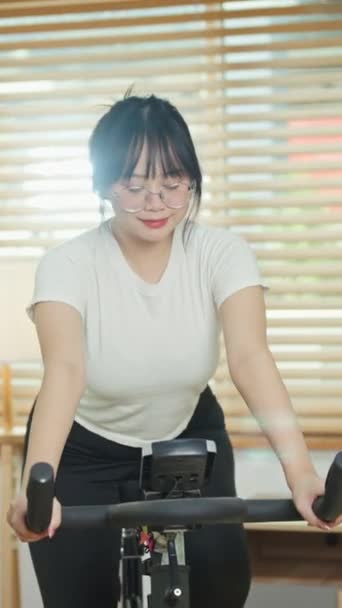 Mujer Asiática Bastante Joven Haciendo Cardio Bicicleta Estacionaria Casa Concepto — Vídeos de Stock