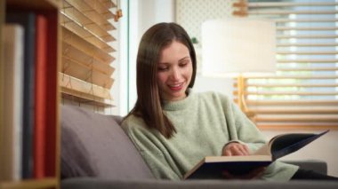 Tasasız beyaz kadın kitap okuyor, boş zamanlarını evde geçiriyor..