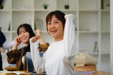 Genç kız öğrenci sınıfta proje başarısını kutlarken heyecanlanıyor..