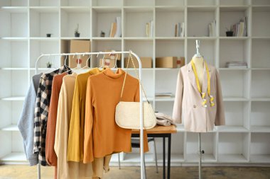 Parmaklıklarda asılı kalın renkler ve tasarımcı giyim mağazasında manken. Giysi perakende konsepti.