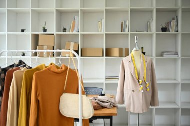 Tasarımcı giyim mağazasında toprak rengi süveter koleksiyonu olan demiryolu.