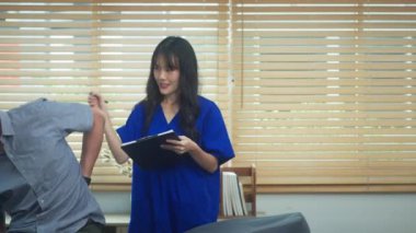 Bir rehabilitasyon kliniğinde fizyoterapist tarafından yapılan bel muayenesi sırasında genç bir hasta..