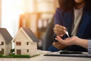 Afro-Amerikan 'ın yeni sahibine evinin anahtarlarını verirken çekilmiş görüntüsü. Özellik satın alma kavramı.