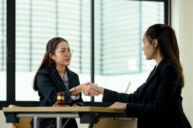 Profesyonel avukat, yasal tavsiye verdikten sonra müvekkilinin elini sıkıyor. Hukuk ve adalet kavramı.