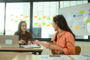 Modern çalışma alanındaki projeyi tartışan mutlu iş arkadaşları.