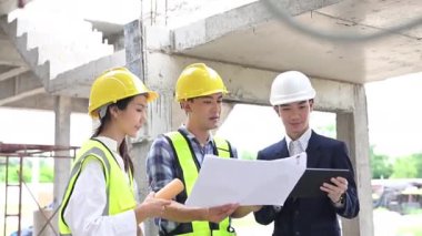 Mühendisler ve iş adamlarından oluşan bir ekip inşaat alanındaki proje hakkında detaylar planlıyor..