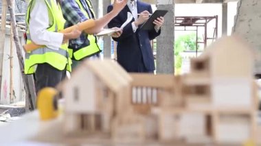 İnşaat alanında inşaat işçileri, inşaat alanının detaylarını planlıyorlar..