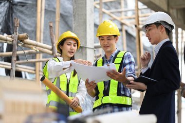 Mühendisler ve erkek yatırımcılar inşaat alanında proje geliştirme planları yapıyorlar.