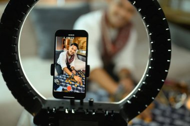 Neşeli tarot okuyucusu çevrimiçi tahmin yapıyor ve akıllı telefonla video kaydediyor..