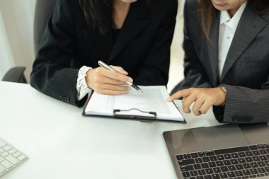 Çalışma alanındaki raporları gözden geçiren ya da düzenleyen iş arkadaşlarının kesilen görüntüleri.