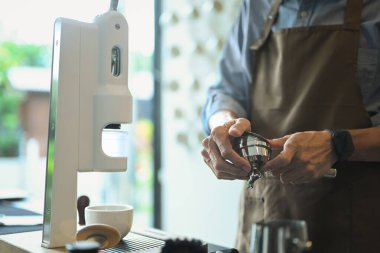 Kahve yapmak için kahve makinesini kullanan bir el kahve dükkanında espresso yapan bir adam..