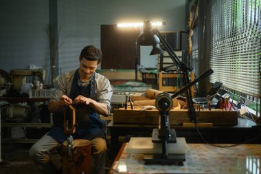 Esnaf atölyede iğne ve iplikle deri dikiyor..