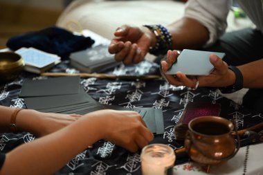 Erkek tarot okuyucusu genç bayan müşteriler için geleceği tahmin ediyor. Tahmin ve kehanet kavramı.