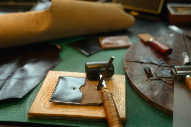 Siyah deri cüzdan ve tezgahtaki el işi aletleri. Küçük işletme ve el yapımı konsept.