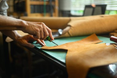 Zanaatkârın kesme paspası üzerinde çalışırken yakın plan görüntüsü.