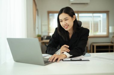 Ev ofisinde laptopuyla çalışan çekici genç girişimci..