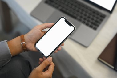 Genç kadın ellerini beyaz ekranlı cep telefonuyla kapat, kanepede otur..