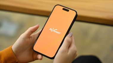 Chiang Mai, Tayland - 5 Ağustos 2024: Payonez uygulamalı akıllı telefon tutan kadın. Paeveryone, dünya çapında bir online ödeme sistemidir..