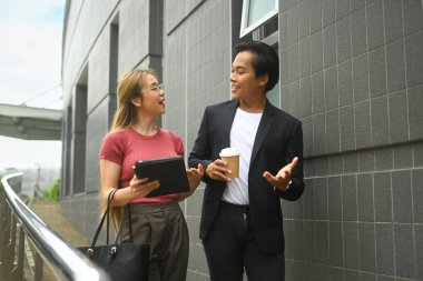 Ofis binasının önünde dostça sohbet eden iki iş adamı..