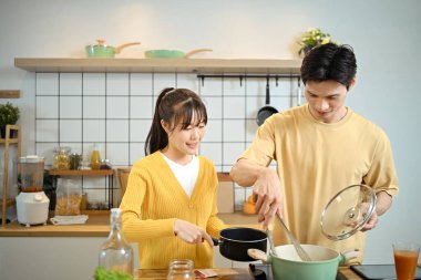 Sevecen genç bir çift mutfak tezgahında keyifli bir yemek deneyimi yaşıyor..