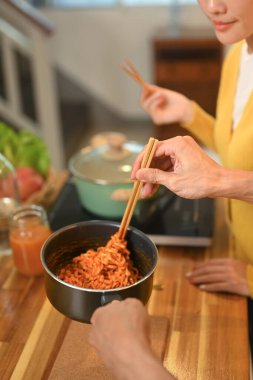 Genç çift, ahşap tezgahta taze pişmiş erişte yiyor..