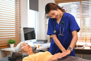 Huzurlu, gözleri kapalı yaşlı bir kadın terapistle Reiki 'nin tedavisini görüyor. Alternatif tıp konsepti.