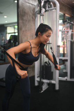 Çekici atletik kadın spor salonunda göğüs sineği egzersizine odaklanıyor..