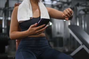 Eğitimden sonra dinlenen ve nabzını kontrol eden sağlıklı genç bir kadın..