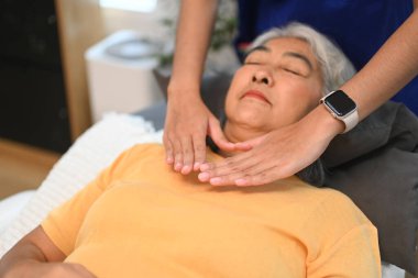 Reiki 'nin terapistle tedavi gördüğü yaşlı bir kadın. Alternatif tıp ve Reiki tekniği kavramı.