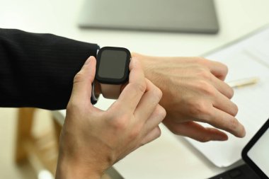 Resmi olarak giyinmiş genç iş adamlarının akıllı adam kontrol saatlerini kapatın. Zaman yönetimi kavramı.
