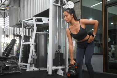 Spor salonunda kettlebell ile egzersiz yapan güzel bir bayan. Spor ve sağlıklı yaşam tarzı konsepti.