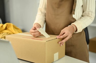 Küçük işletme sahibi kadın müşteriler için sipariş hazırlıyor. Çevrimiçi satış ve e-ticaret kavramı.