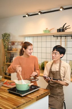 Sevecen genç bir çift ev mutfağında öğle yemeği yiyor..