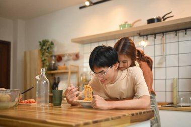 Evde rahat bir mutfakta vakit geçiren genç bir çift arasındaki hassas an..