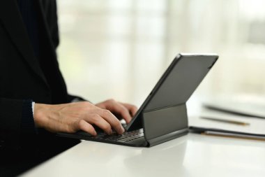 Dijital tabletin klavyesinde daktilo yazan işadamlarının yakın çekim görüntüleri