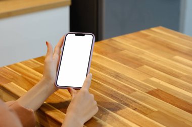 Kadınların elleri ahşap masada akıllı telefon kullanıyor. Yakın çekim..