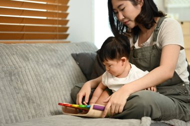 Sevimli bir çocuk ve anne rahat oturma odasında oyuncaklarla oynuyorlar. Çocukluk ve bakım konsepti.