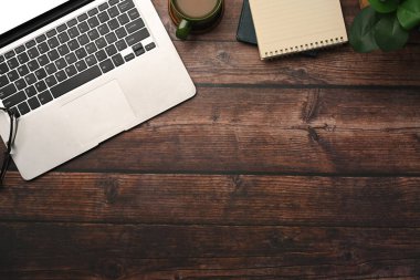 Laptop bilgisayar, bir fincan kahve ve ahşap masaya not defteri. Üst Manzara Düz Yat.