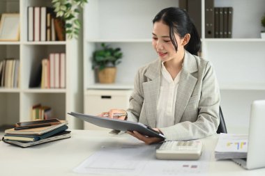 Profesyonel iş kadını ofis masasında mali veri raporu hazırlıyor..