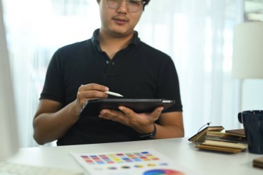 Ofiste bir dijital tablet ve stil ile çalışan iç mimar, tasarım projesi çizimi veya incelemesi.