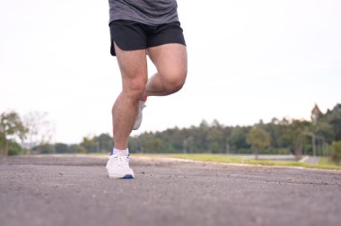 Atletin bacakları açık havada koşuyor. Fitness ve sağlıklı yaşam tarzı konsepti.