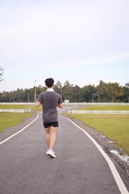 Huzurlu bir parkta koşan atletik adam. Fitness ve sağlıklı yaşam tarzı konsepti.