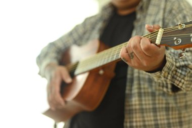 Adamın akustik gitar akorları çalışmasına yaklaş. Boş zaman aktivitesi ve hobi konsepti.
