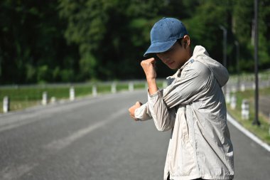 Genç sporcu kollarını açmış parkta sabah antrenmanına hazırlanıyor..
