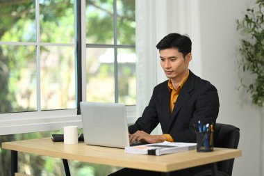 Modern bir ofiste çalışmaya odaklanan profesyonel iş adamı..