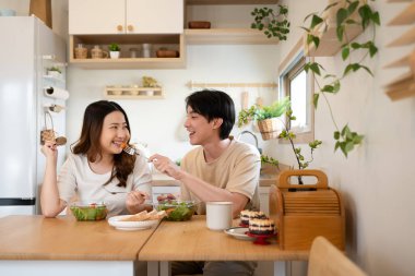 Mutlu çift taze salatanın ve ev yapımı ikramların tadını çıkarıyor..