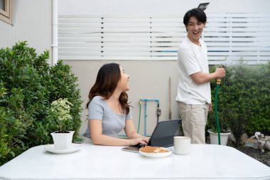 Neşeli Asyalı çift arka bahçede birlikte vakit geçiriyor..