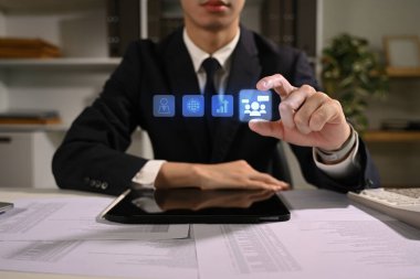 İş adamı iş stratejisi ve analitik için sanal simgelerle etkileşime geçiyor.